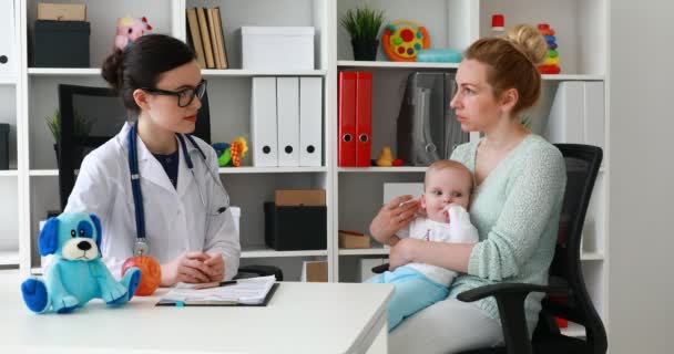 Giovane Medico Donna Che Offre Mela Alla Madre Con Bambino — Video Stock
