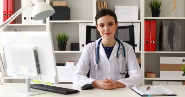 Médico Sentado Lugar Trabajo Levantando Mano Barbilla Mirando Cámara — Vídeos de Stock