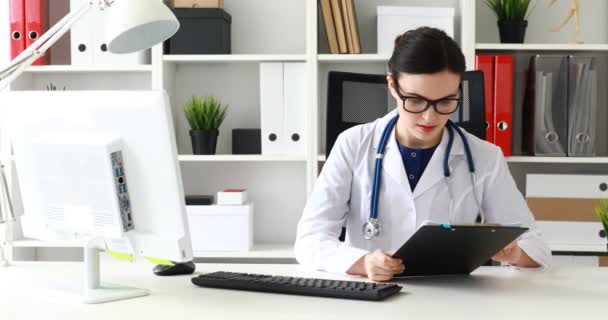 Médico Leyendo Tarjeta Médica Quitándose Las Gafas — Vídeo de stock