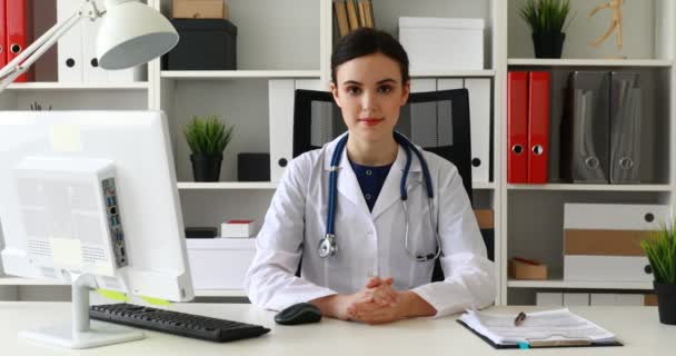 Doctor White Lab Coat Sitting Workplace Bright Office Looking Camera — Stock Video