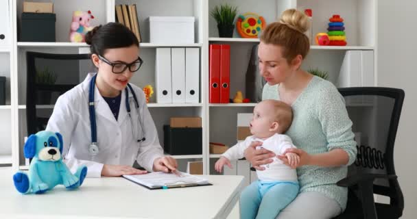 Kinderarzt Sitzt Arbeitsplatz Und Erzählt Patienten Die Diagnose — Stockvideo