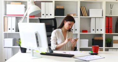 Office-sandalyede oturan ve smartphone kullanarak iş kadını