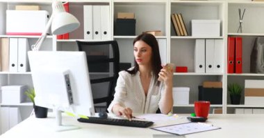 bilgisayarda çalışarak ve smartphone kullanarak iş kadını