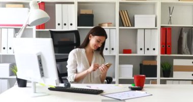 işkadını smartphone kullanarak ve gülümseyen beyaz bluz 