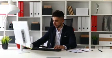 Ofis koltuğu bilgisayar üzerinde çalışan iş adamı