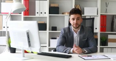 Genç işadamı modern ofiste kamera arıyor.