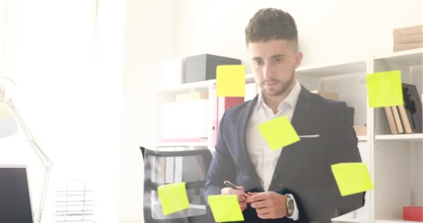 Geschäftsmann Mit Stift Der Hand Denkt Nahe Glaswand — Stockvideo