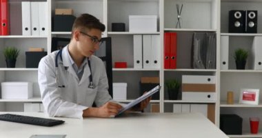Kağıt gösterilen ve kameraya bakarak genç doktor