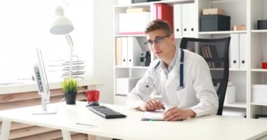 Genç doktor çalışma alanı'ndaki kamera bakıyor