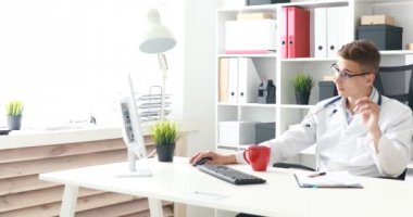 Genç doktor çalışma alanı'nda kahve içme