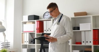 Genç doktor belgeleri işyerinde bakarak