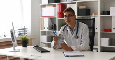 Doktor su şişe masanın üstüne koy. 