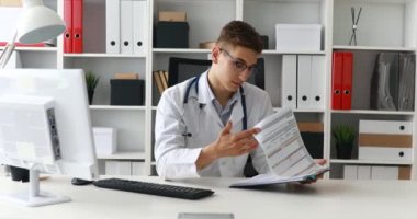 Belgelerle çalışma ve gözlükleri çıkar alarak genç doktor