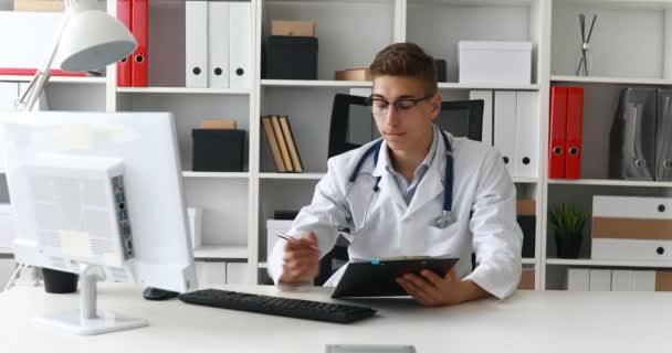 工作在计算机的年轻医生在工作场所 — 图库视频影像