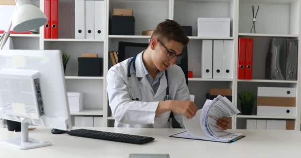 Unga Läkare Tittar Dokument Arbetsplatsen — Stockvideo