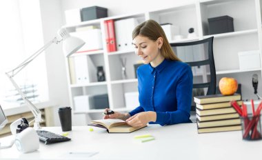 Genç bir kız bir bilgisayar masada oturur ve sarı bir işaret onun elinde tutar. Önce kız açık bir kitap yatıyor.