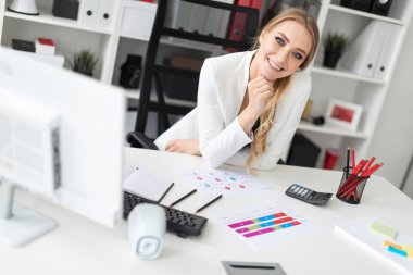 Ofisteki bilgisayar masasında genç bir kız oturuyor..