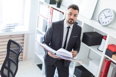 Ofis ve belgeler klasörüyle ile verilirse rafa yakın duran adam.