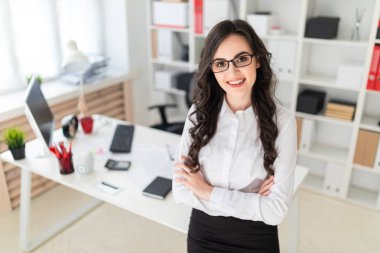 Güzel bir genç kız Ofis Masası göğsüne sıktı elleri duruyor..