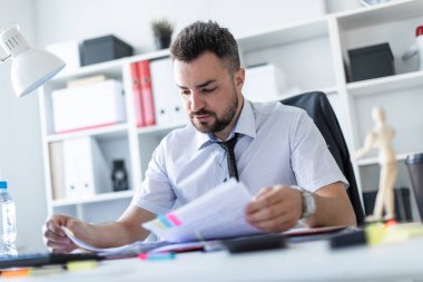 Bir adam oturuyor ve verilirse aracılığıyla belgeleri.