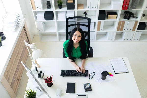 Draufsicht eines jungen Mädchens, das am Schreibtisch sitzt und auf einer Tastatur tippt. — Stockfoto