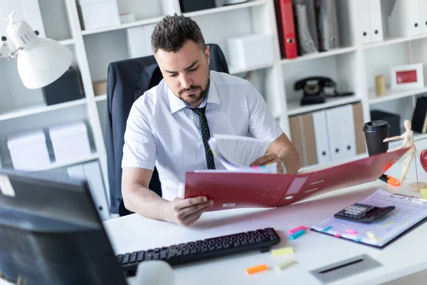 Bir adam ofiste masada oturan ve belgeleriyle çalışma.