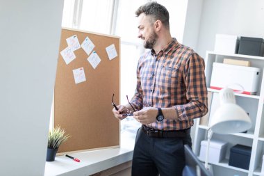 Adam çıkartmaları ile yönetim kurulu yakınındaki ofiste ayakta ve bir besside önde gelen.