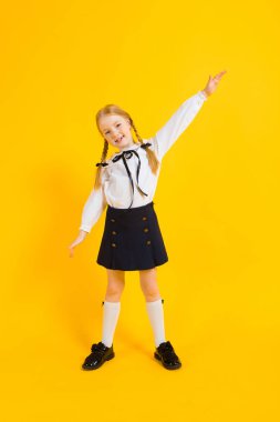 Sarı bir arka plan üzerinde kırmızı pigtails kız. Güzel kız kollarını dışarı uzatılmış.