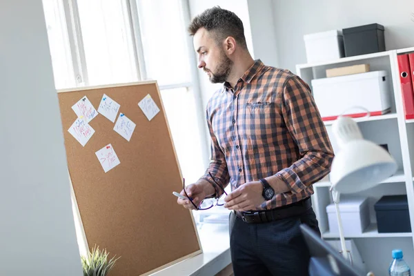 Adam çıkartmaları ile yönetim kurulu yakınındaki ofiste ayakta ve bir besside önde gelen.