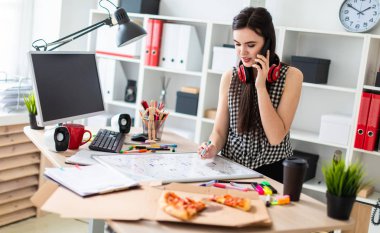 Genç bir kız bir masanın ayakta, yeşil bir işareti onun elinde tutan ve Evet. Kızlar kulaklık boynuna asmak.