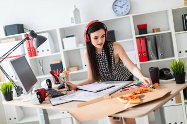 Genç bir kız tablonun duruyor, bir yeşil işareti onun elinde tutan ve bir parça pizza alır. Önce kız masanın üzerinde manyetik bir pansiyondur. Kulaklıklar giyen kız kafasına.