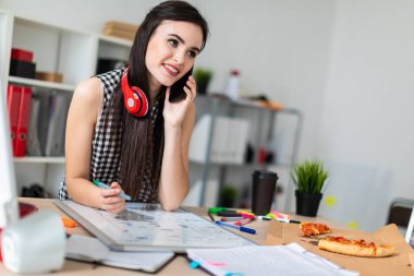 Genç bir kız bir masanın ayakta, yeşil bir işareti onun elinde tutan ve Evet. Kızlar kulaklık boynuna asmak.