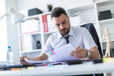 Bir adam oturuyor ve verilirse aracılığıyla belgeleri.