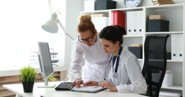 Kadın doktorlar ofiste belgelerle çalışıyorlar.