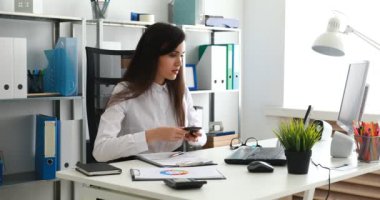 smartphone üzerinde konuşmak ve modern ofisinde çalışan bir işkadını