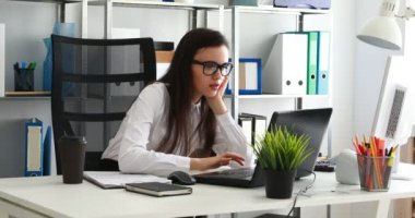 esneme ve modern ofiste dizüstü bilgisayar kullanarak bir işkadını