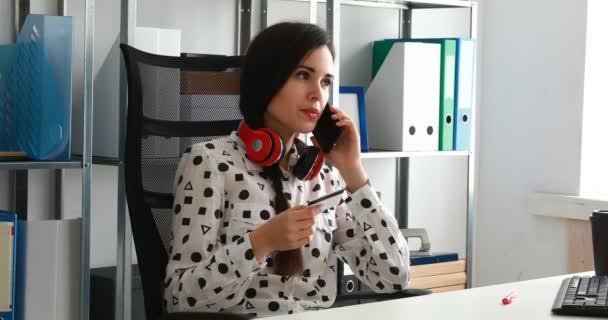 Mujer Negocios Auriculares Rojos Con Tarjeta Crédito Hablando Teléfono Inteligente — Vídeo de stock