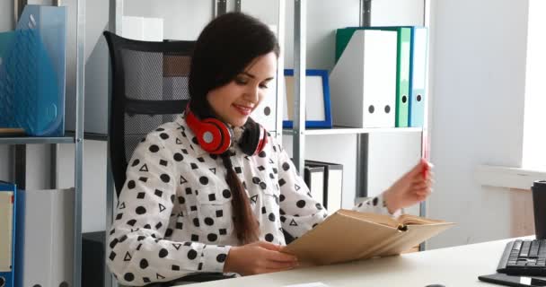 Vrouw Met Rode Hoofdtelefoon Schouders Lezen Boek Moderne Kantoren — Stockvideo