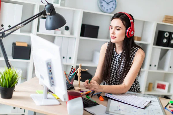 Genç bir kız bir masanın ayakta, yeşil kalem tutan ve ekrana bakarak. Önce kız masanın üzerinde manyetik bir pansiyondur. Kulaklıklar giyen kız kafasına.