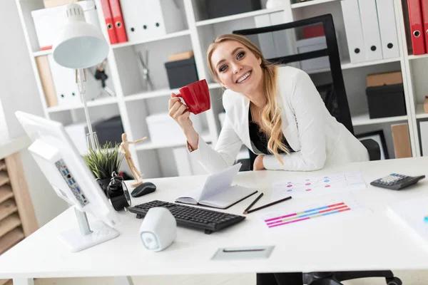 Genç bir kız ofiste bilgisayar masasında oturan ve bir holding. Kız masada daha önce diyagram olan.