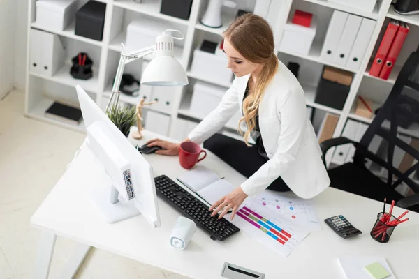 Het jonge meisje ging op het bureau zitten en werkte met een computer en documenten.. — Stockfoto