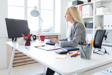 Genç kız ofiste bilgisayar ve belgeler ile çalışma.