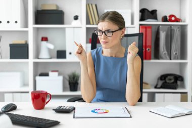 Genç bir kız ofiste bir masada oturur ve bir belgeyi içeren bir grafik görünüyor.