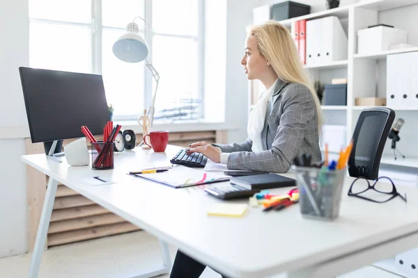 Genç kız ofiste bilgisayar ve belgeler ile çalışma.