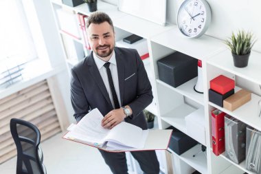 Ofis ve belgeler klasörüyle ile verilirse rafa yakın duran adam.