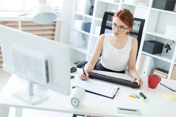 Vacker ung flicka i kontoret arbetar med pennan, dokument och dator. — Stockfoto