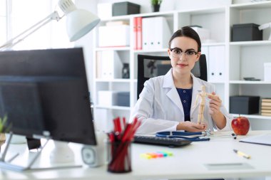 Beyaz bir elbise içinde güzel bir genç kız bir masada oturan ve bir adam ahşap bir rakam onun elinde tutan.