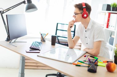 Bir genç adam gözlük ve kulaklık bilgisayar çalışıyor. Adam bir manyetik kurulu ve işaretleri olmadan.