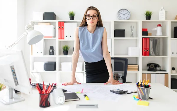 Menina bonita no escritório está de pé perto da mesa e colocar as mãos sobre ele . — Fotografia de Stock