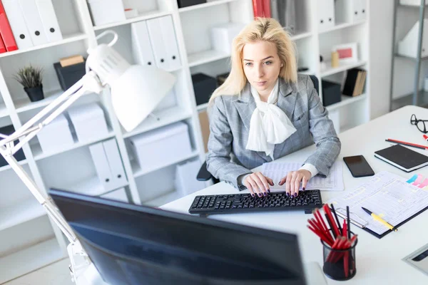 Genç kız ofiste bilgisayar ve belgeler ile çalışma.